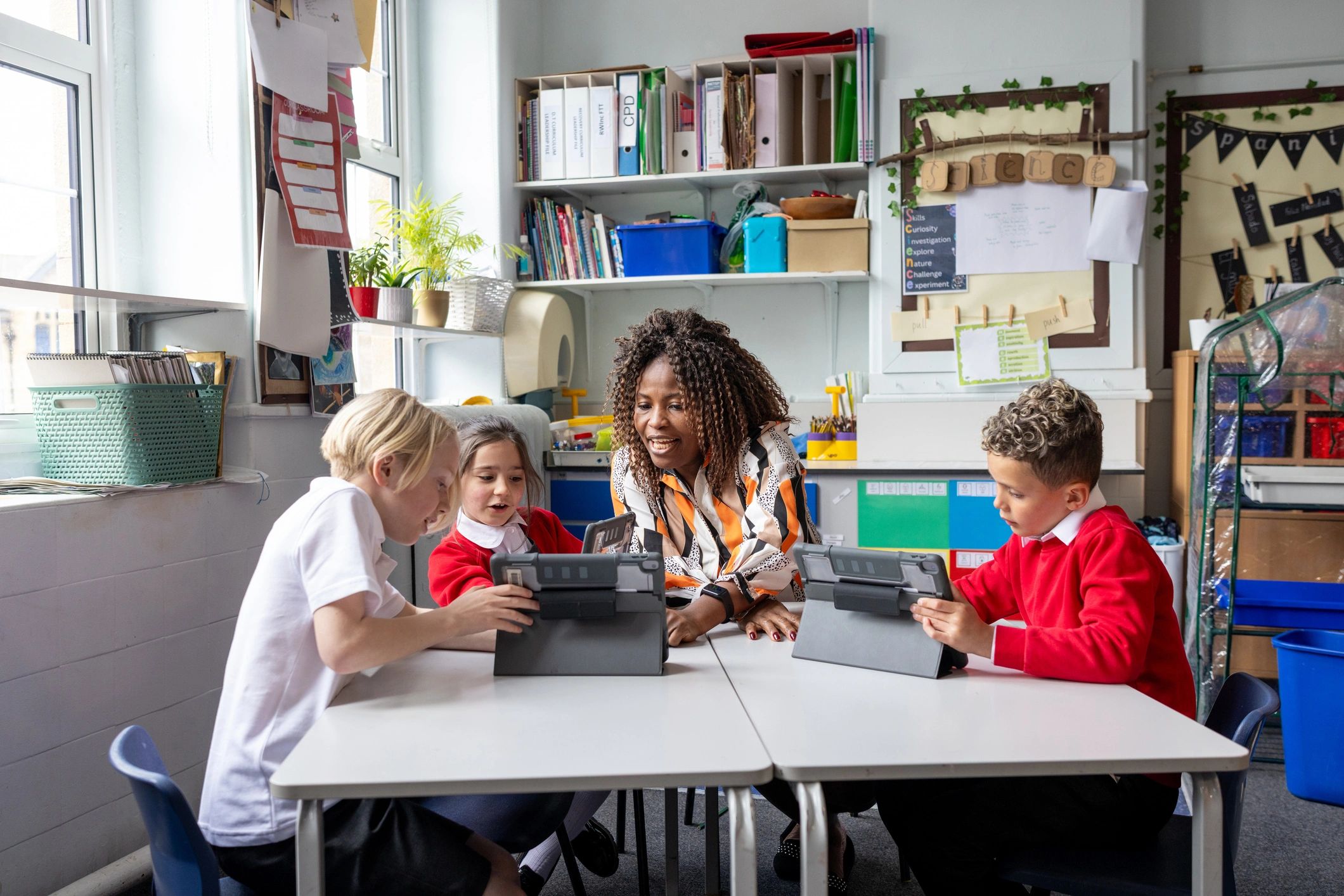 Teacher supporting students using digital devices in class