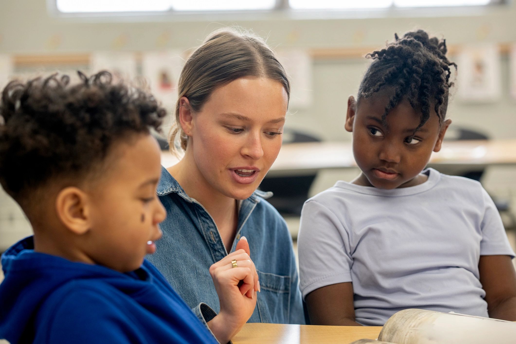 Black African instructor supporting students in a classroom